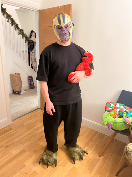 Tom Foley dressed in claw feet and a Thanos mask, holding Elmo in his arms.